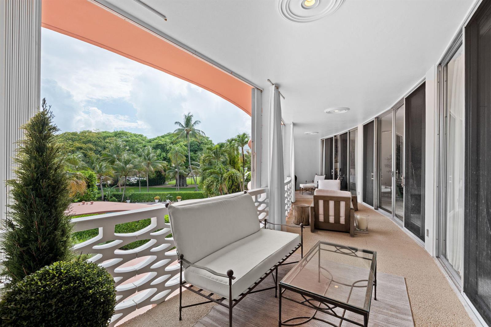 A balcony features a white sofa, glass coffee table, and views of palm trees — 315 S Lake Drive # 3d, Palm Beach FL 33480, PALM BEACH, FL