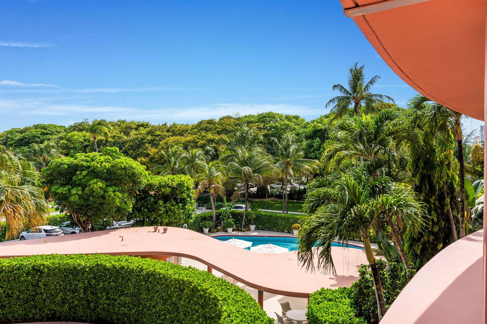 An elevated view of a swimming pool surrounded by palm trees and lush green hedges — 315 S Lake Drive # 3d, Palm Beach FL 33480, PALM BEACH, FL