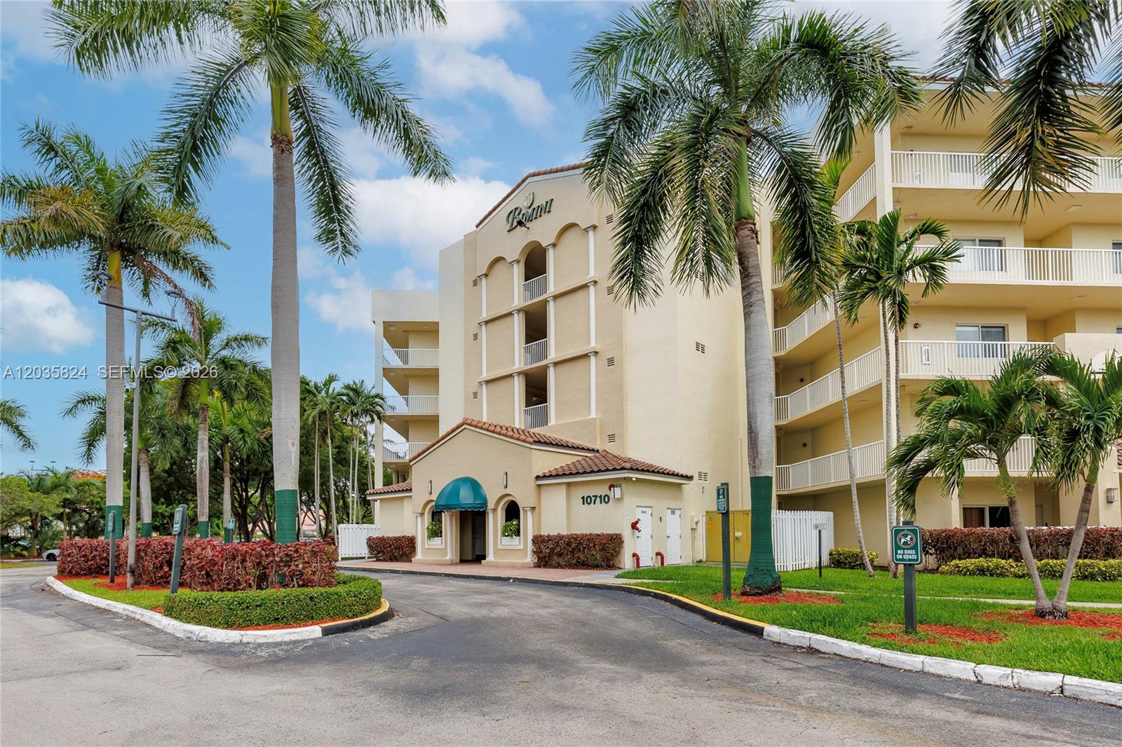 A multi-story apartment building with palm trees and a paved driveway in front — 10710 NW 66th St # 104, Doral FL 33178, DORAL, FL
