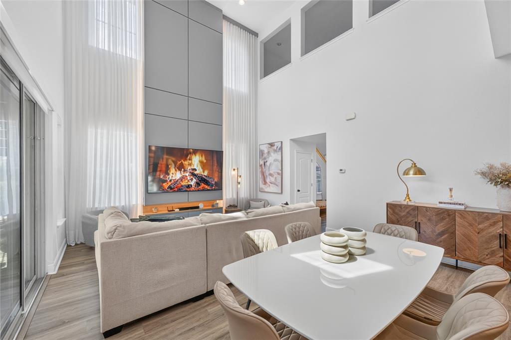 A living and dining area features a tall gray fireplace wall and white curtains — 13660 CHAUVIN AVENUE, ORLANDO, FL