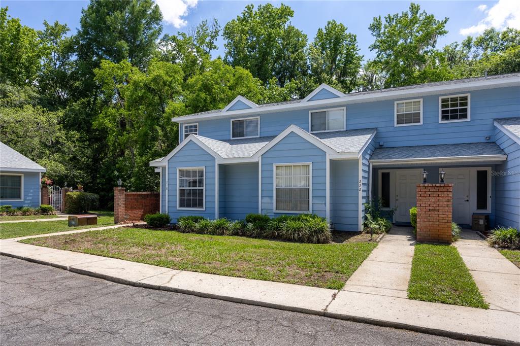 A blue two-story townhouse with a brick pillar and a concrete walkway — 218 NW 50TH BOULEVARD UNIT K, GAINESVILLE, FL