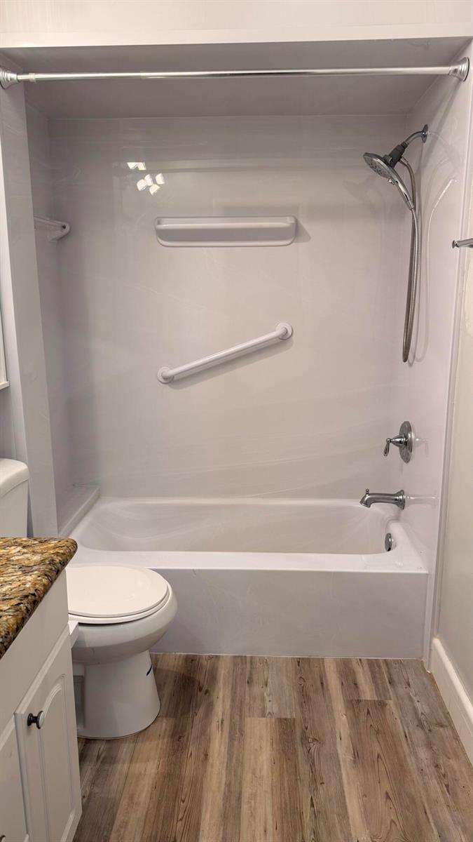A bathroom featuring a white bathtub and shower surround with a grab bar and handheld sprayer — 11000 S Ocean Drive # 12, Jensen Beach FL 34957, JENSEN BEACH, FL