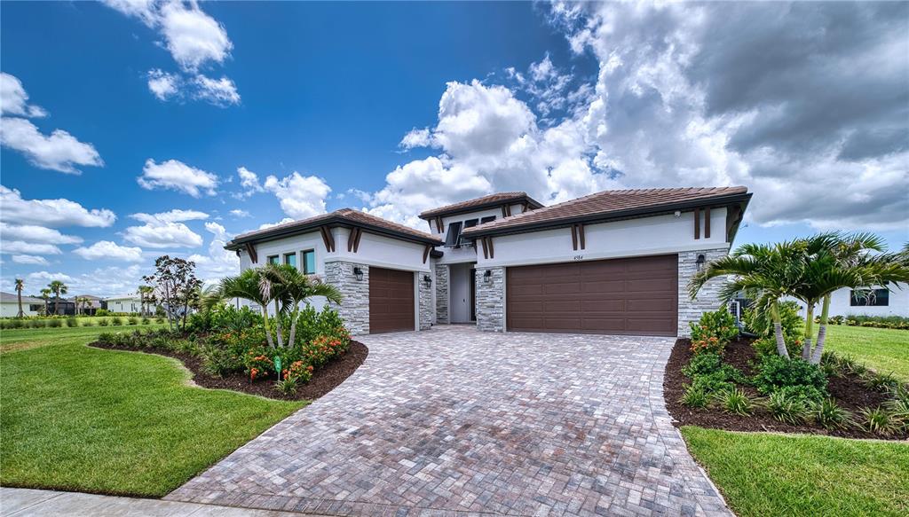 A single-story house with a stone facade, a paver driveway, and a three-car garage — 4584 CEDRON COURT, SARASOTA, FL