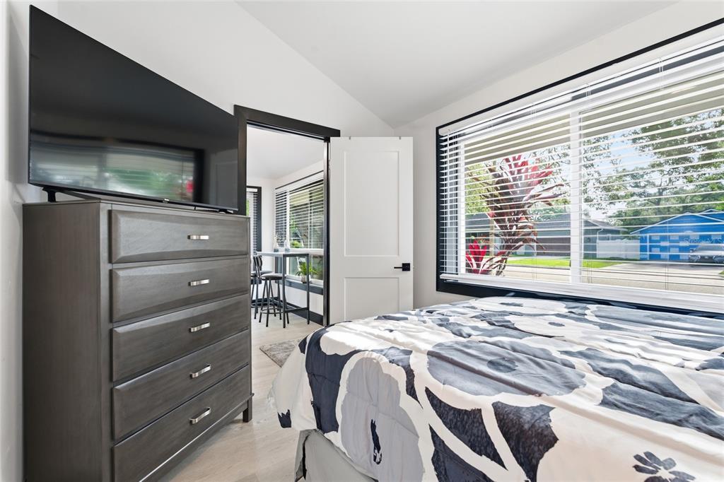 A bedroom features a dark wood dresser, a floral comforter, and a window with blinds — 2111 42ND STREET S, ST PETERSBURG, FL