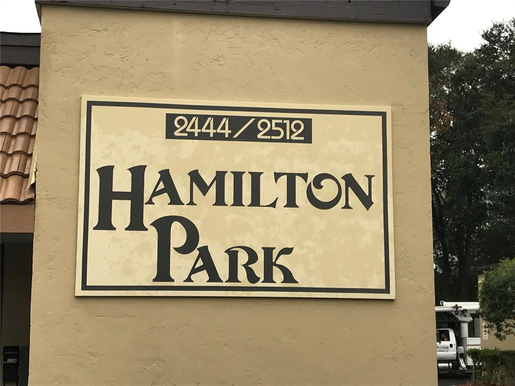 A beige wall features a sign for Hamilton Park with the numbers 2444 and 2512 — 2512 NE 1ST BOULEVARD UNIT 700, GAINESVILLE, FL