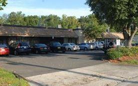 A parking lot sits in front of a single-story commercial building with a dark roof — 2512 NE 1ST BOULEVARD UNIT 700, GAINESVILLE, FL