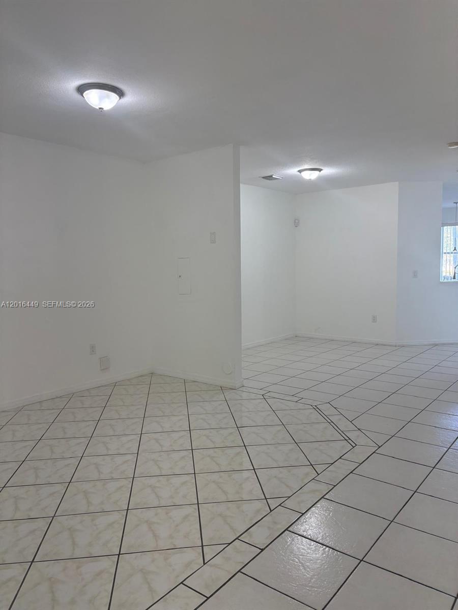 An interior view shows a room with white walls and light-colored diagonal floor tiles — 8525 SW 165th Pl # 8525, Miami FL 33193, MIAMI, FL