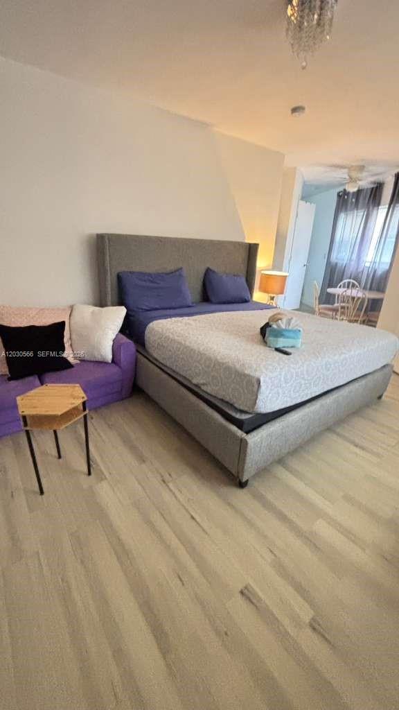 A bedroom features a gray upholstered bed, a purple sofa, and light wood-look flooring — 109 SE 9th St # 2, Hallandale Beach FL 33009, HALLANDALE BEACH, FL