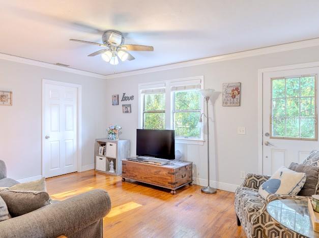 A living room features hardwood floors, a ceiling fan, a television, and a glass-paneled door — 11727 SW 122ND STREET, GAINESVILLE, FL