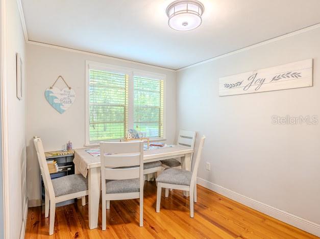A dining area features a white table with four chairs, hardwood floors, and wall decor — 11727 SW 122ND STREET, GAINESVILLE, FL