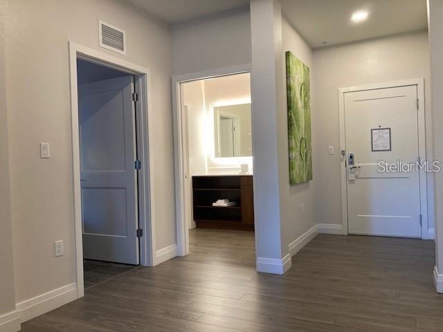 An interior view shows a hallway with wood-look flooring, a doorway, and a bathroom entrance — 14501 GROVE RESORT AVENUE UNIT 2119, WINTER GARDEN, FL