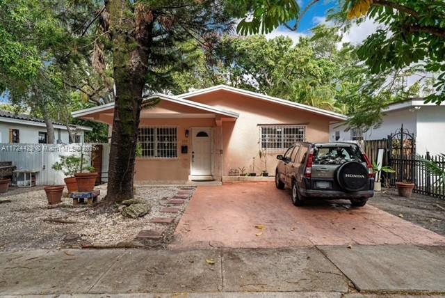 A single-story peach-colored house with a driveway and a parked SUV in the front yard — 133 NE 48th St, Miami FL 33137, MIAMI, FL