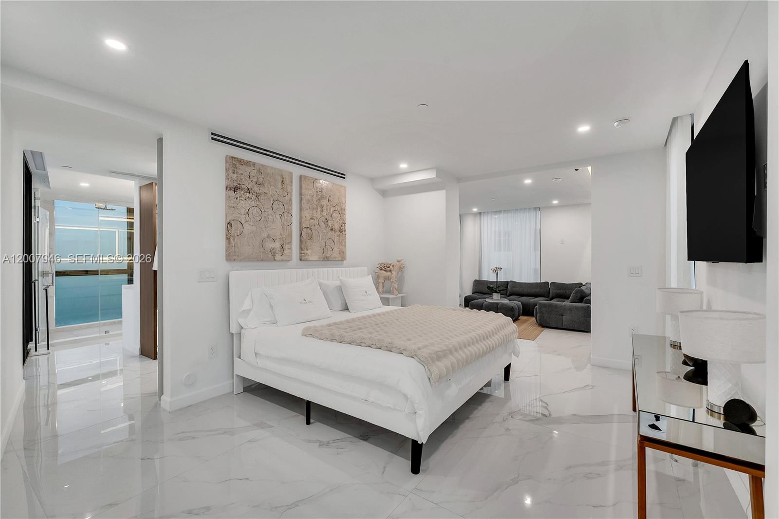 A modern bedroom features a white bed, marble floors, and an adjacent seating area — 11 Century Ln, Miami Beach FL 33139, MIAMI BEACH, FL