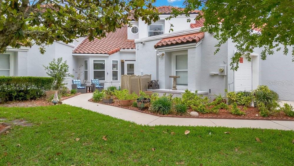 A white stucco house with a red tile roof features a front walkway and landscaping — 2604 ALBION AVENUE, ORLANDO, FL