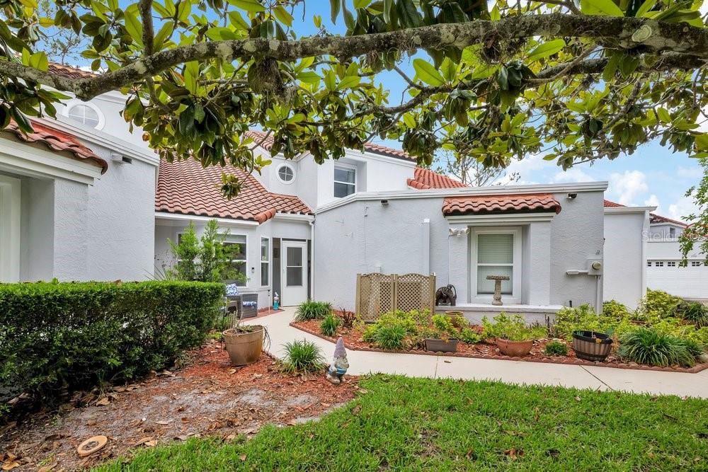 A light gray house exterior features a red tile roof and a concrete walkway — 2604 ALBION AVENUE, ORLANDO, FL