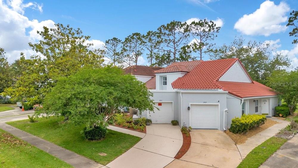 A two-story house with a red tile roof, two garage doors, and a front yard — 2604 ALBION AVENUE, ORLANDO, FL