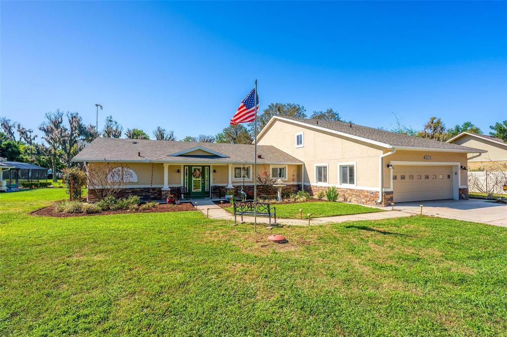 A two-story house with a screened-in pool enclosure sits on a large, grassy lawn — 10220 BUMBLEBEE LANE, LEESBURG, FL