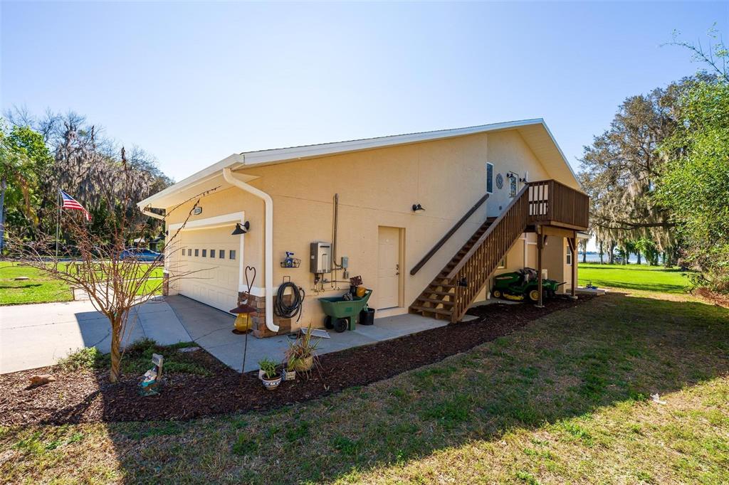 A wooden dock with an owl decoy overlooks a large, calm lake under a clear sky — 10220 BUMBLEBEE LANE, LEESBURG, FL