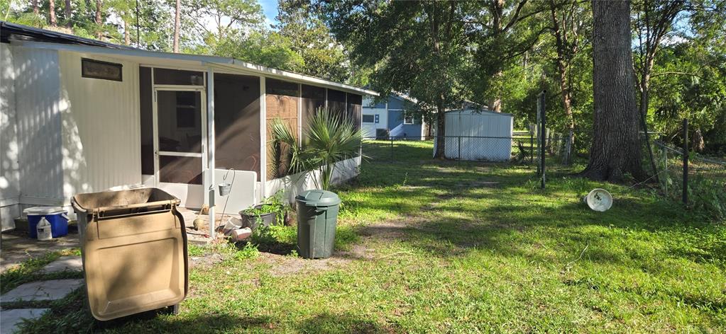 A mobile home with a screened-in porch, a yard, and a detached storage shed — 45627 PENNSYLVANIA STREET, PAISLEY, FL