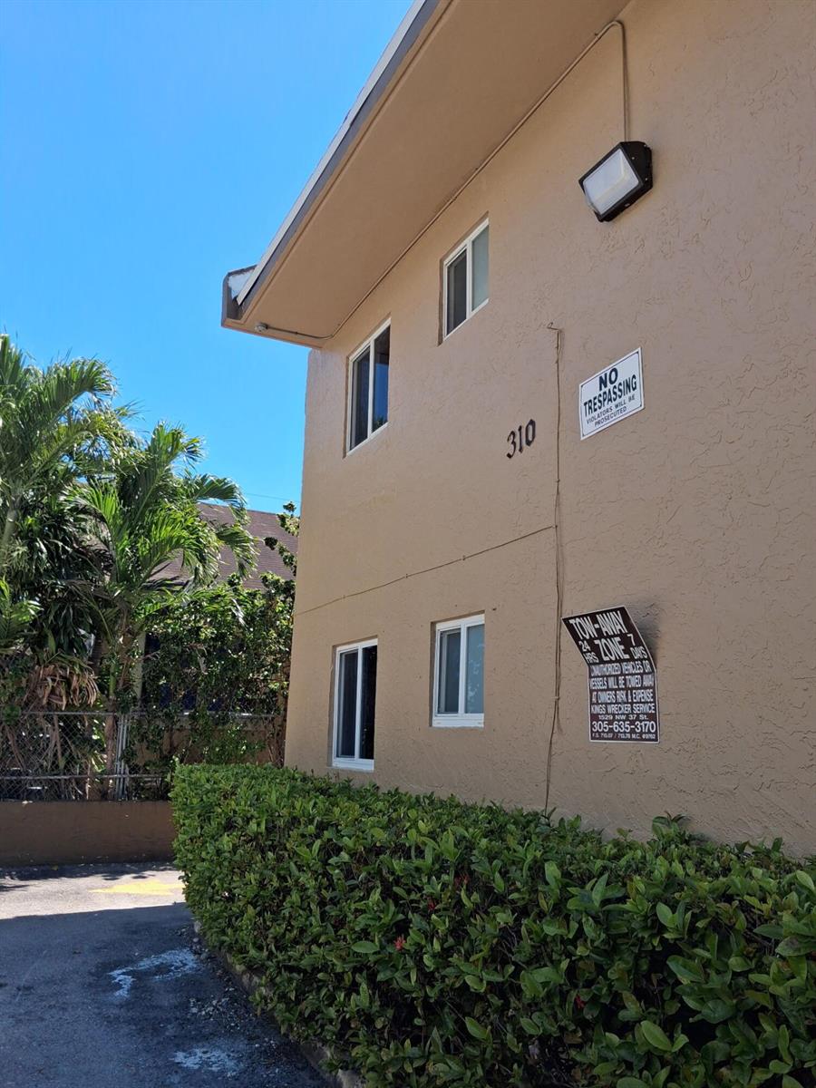 A two-story tan building exterior features a "No Trespassing" sign and a tow-away zone sign — 310 NW 16th Avenue # 1, Miami FL 33125, MIAMI, FL