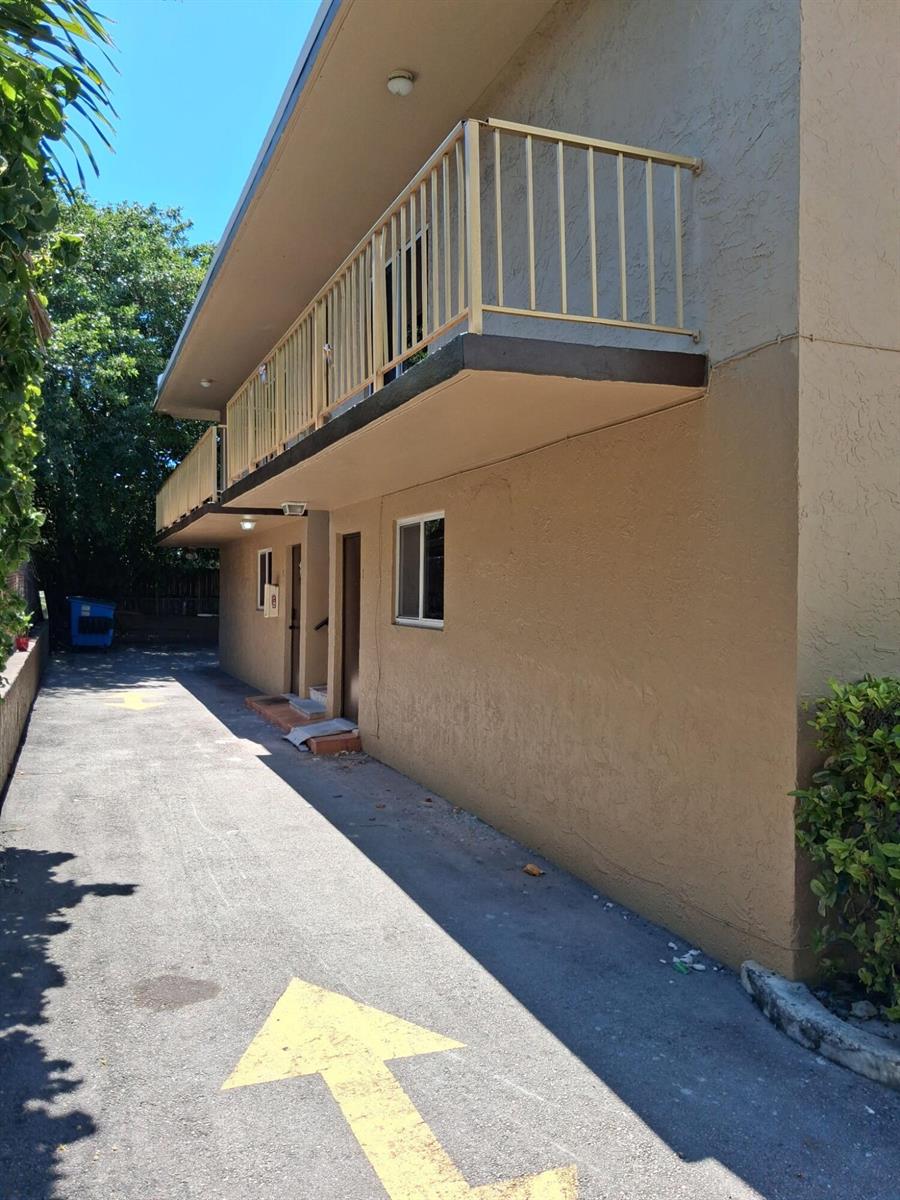 An exterior view of a two-story apartment building with a balcony and a paved driveway — 310 NW 16th Avenue # 1, Miami FL 33125, MIAMI, FL