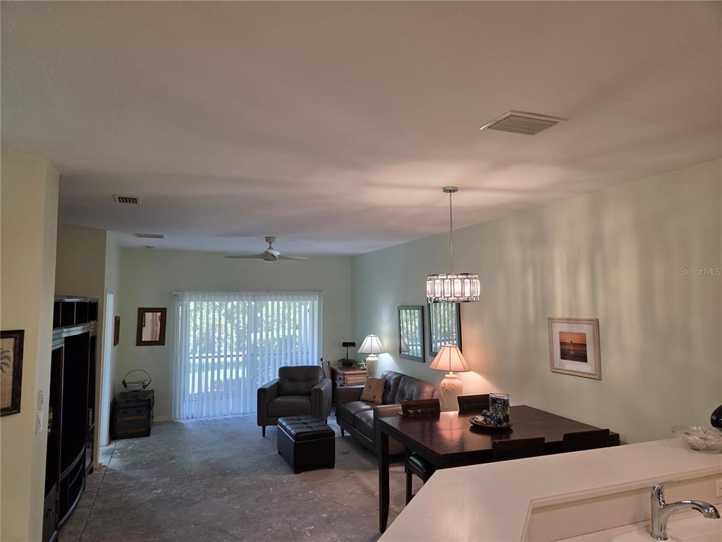 A living and dining area features tile floors, a ceiling fan, and sliding glass doors — 13404 ABERCROMBIE DRIVE, ENGLEWOOD, FL