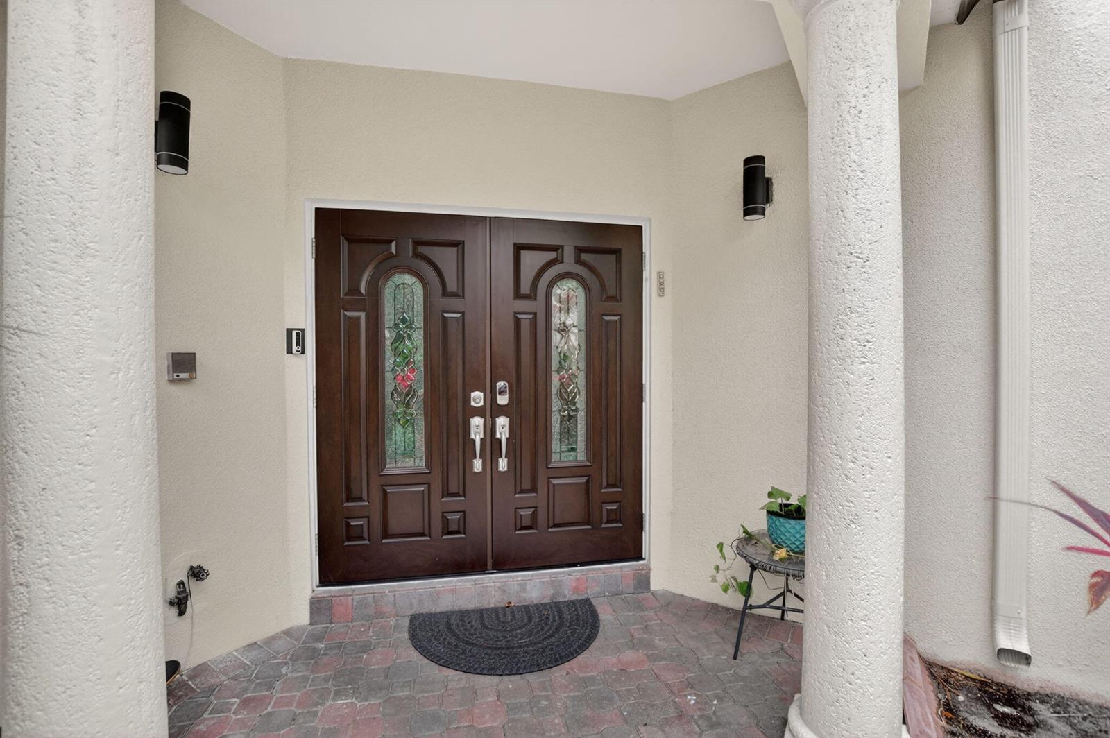 A front entryway features double dark wood doors with stained glass inserts between two columns — 23260 Mirabella Circle N, Boca Raton FL 33433, BOCA RATON, FL
