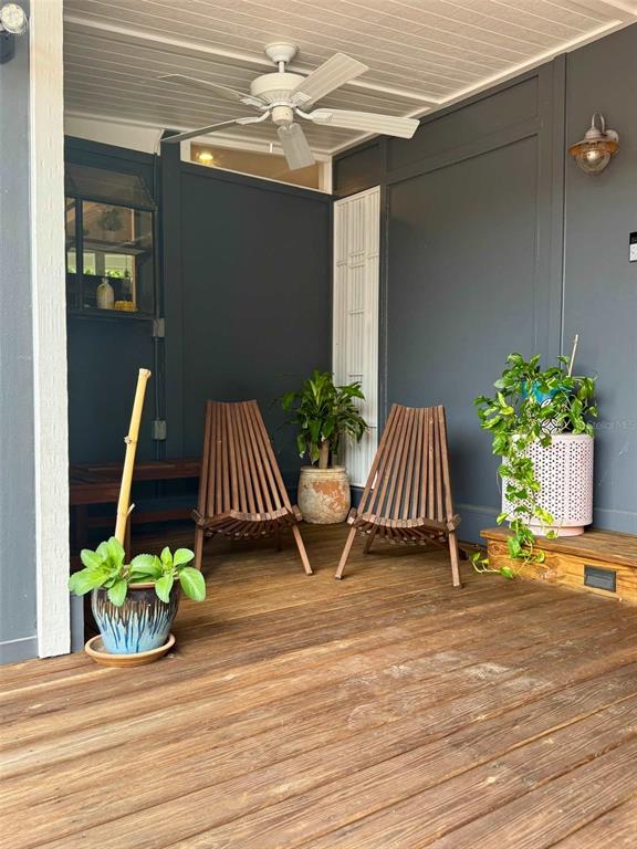 A wooden deck features two slatted chairs, potted plants, and a ceiling fan — 3012 GRAND VIEW AVENUE, CLEARWATER, FL