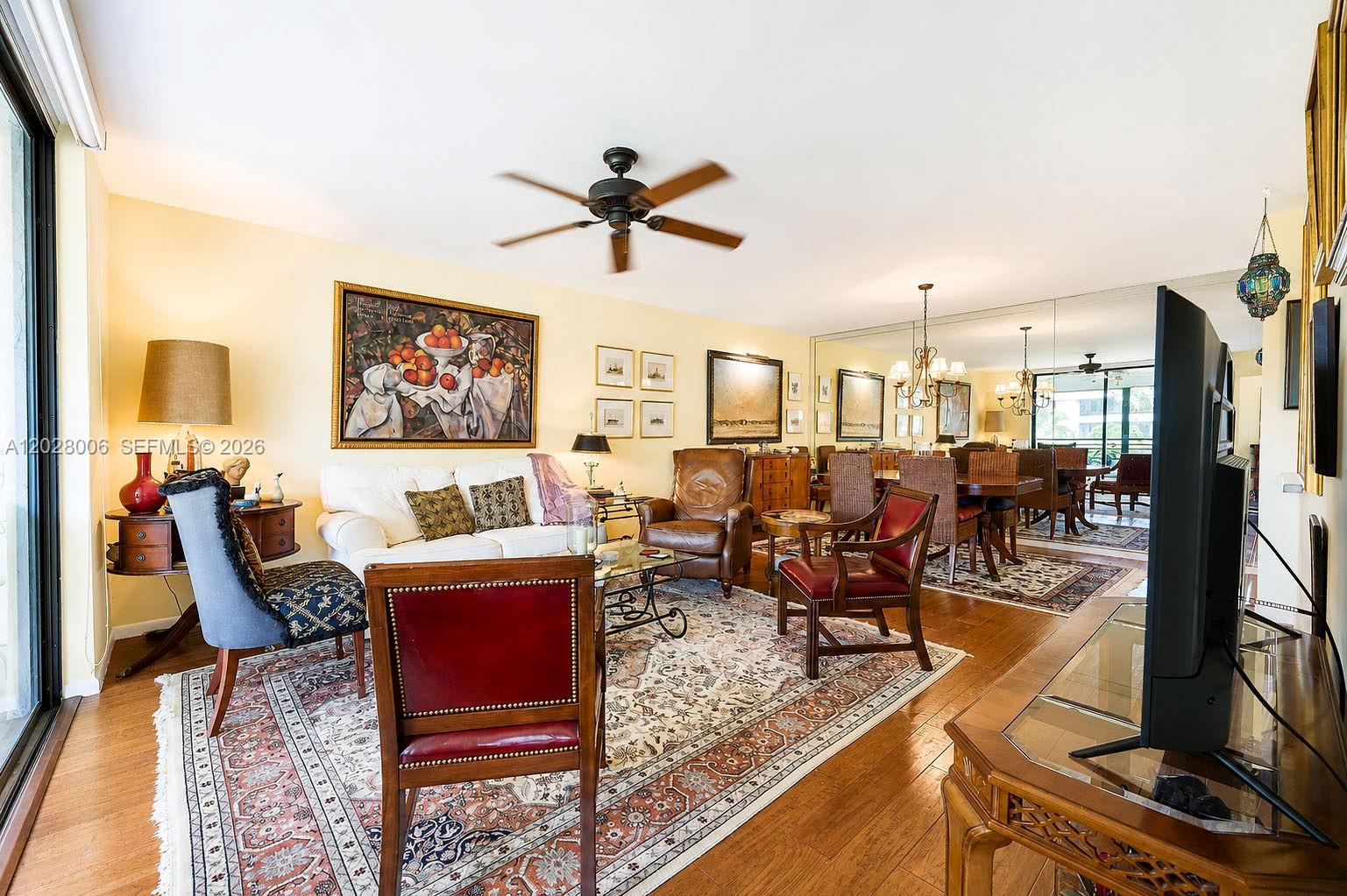 A living and dining area features hardwood floors, a patterned rug, and a ceiling fan — 1450 Sheridan St # 13, Hollywood FL 33020, HOLLYWOOD, FL