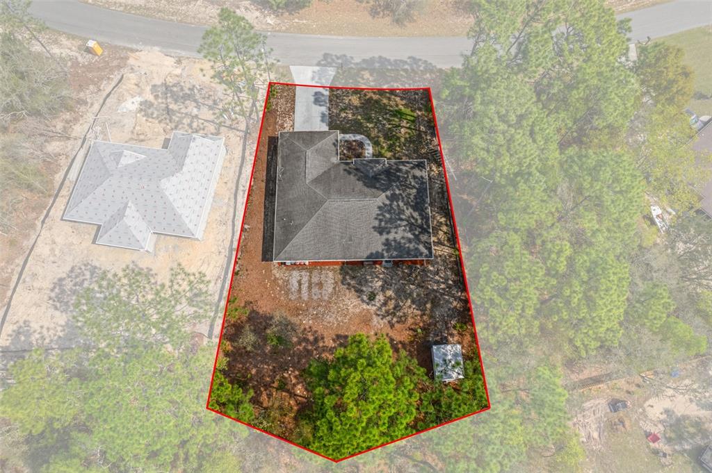 An aerial view shows a house with a dark roof on a wooded, trapezoidal lot — 3212 W CAMILO DRIVE, CITRUS SPRINGS, FL