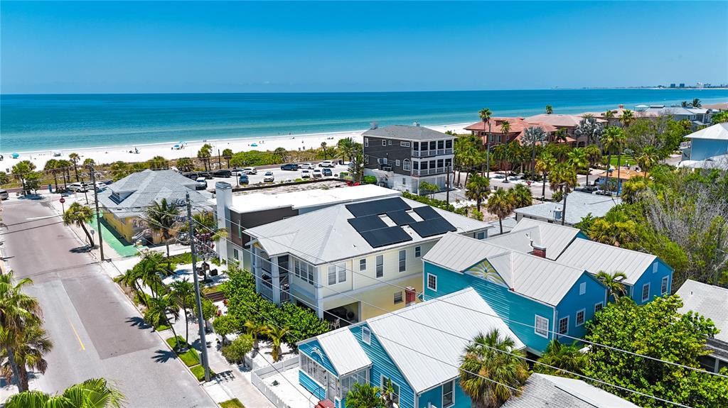 An aerial view shows several coastal homes near a beach with a blue ocean — 105 21ST AVENUE, ST PETE BEACH, FL