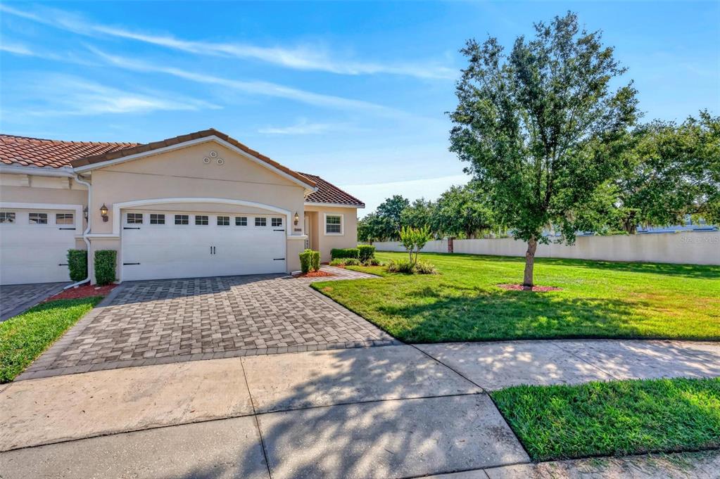 A single-story house with a white garage, a paved driveway, and a grassy side yard — 2101 PAINTER LANE, KISSIMMEE, FL