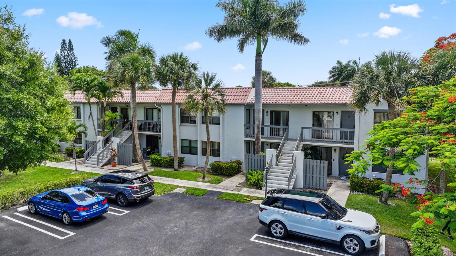 A two-story apartment building with a tiled roof, exterior staircases, and a parking lot — 3275 Frederick Boulevard # 17, Delray Beach FL 33483, DELRAY BEACH, FL