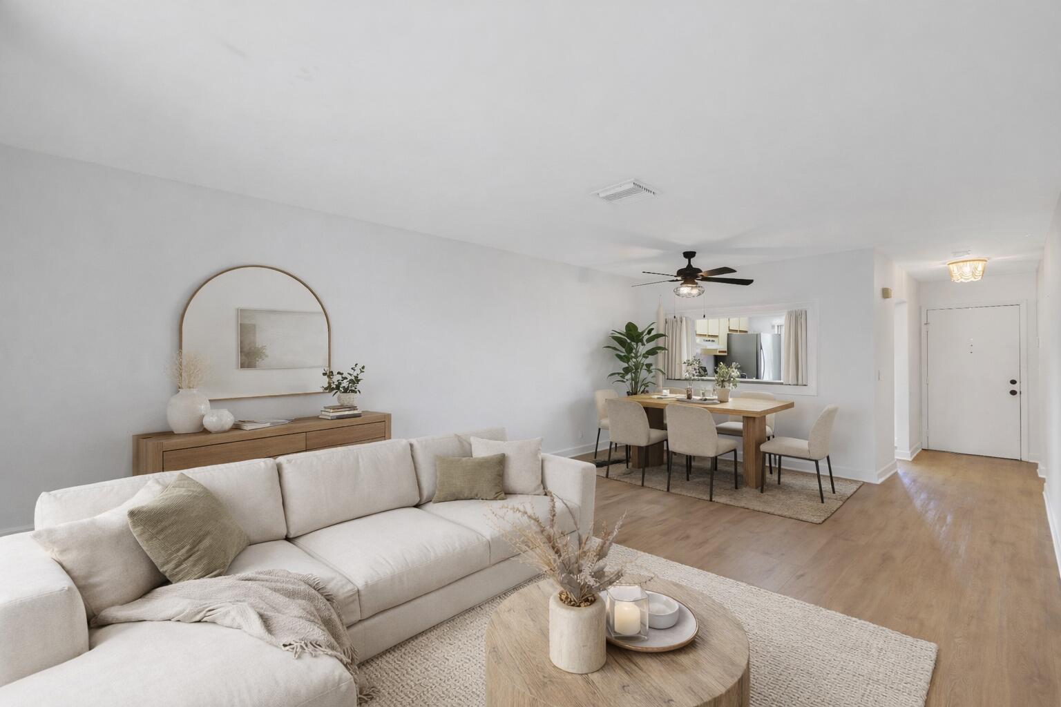 A bright living and dining area features a beige sectional, wooden furniture, and light flooring — 3275 Frederick Boulevard # 17, Delray Beach FL 33483, DELRAY BEACH, FL