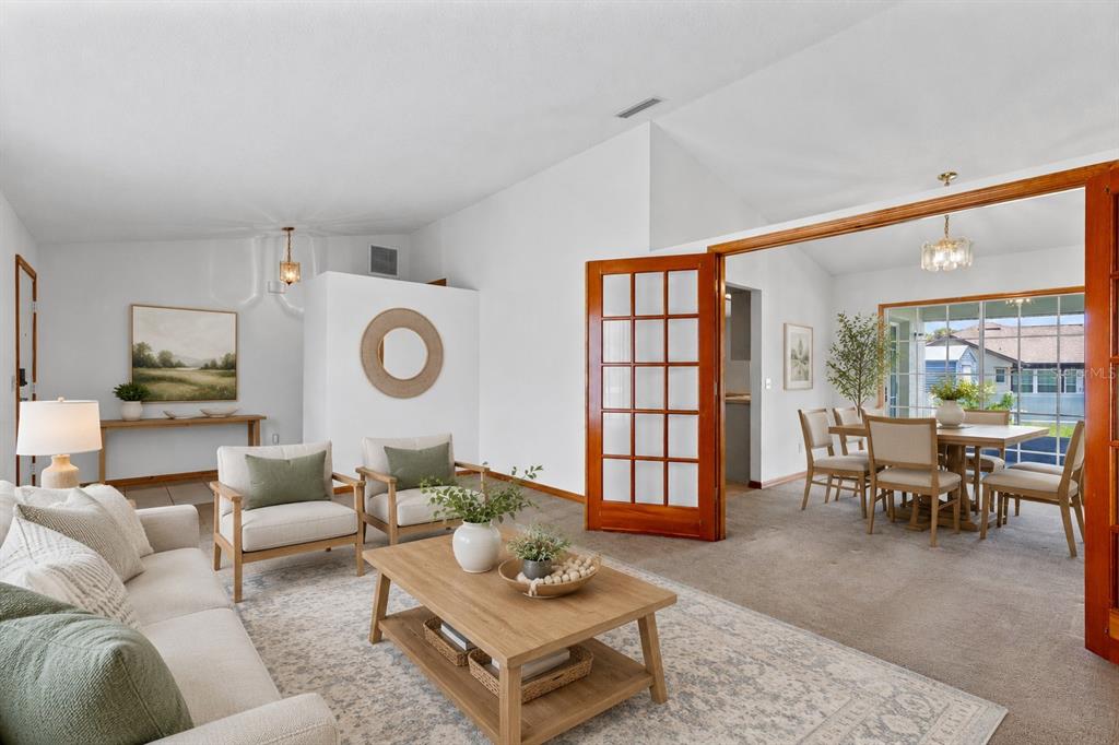 A living room with a coffee table and armchairs leads into a dining area — 602 VICKSBURG STREET, DELTONA, FL