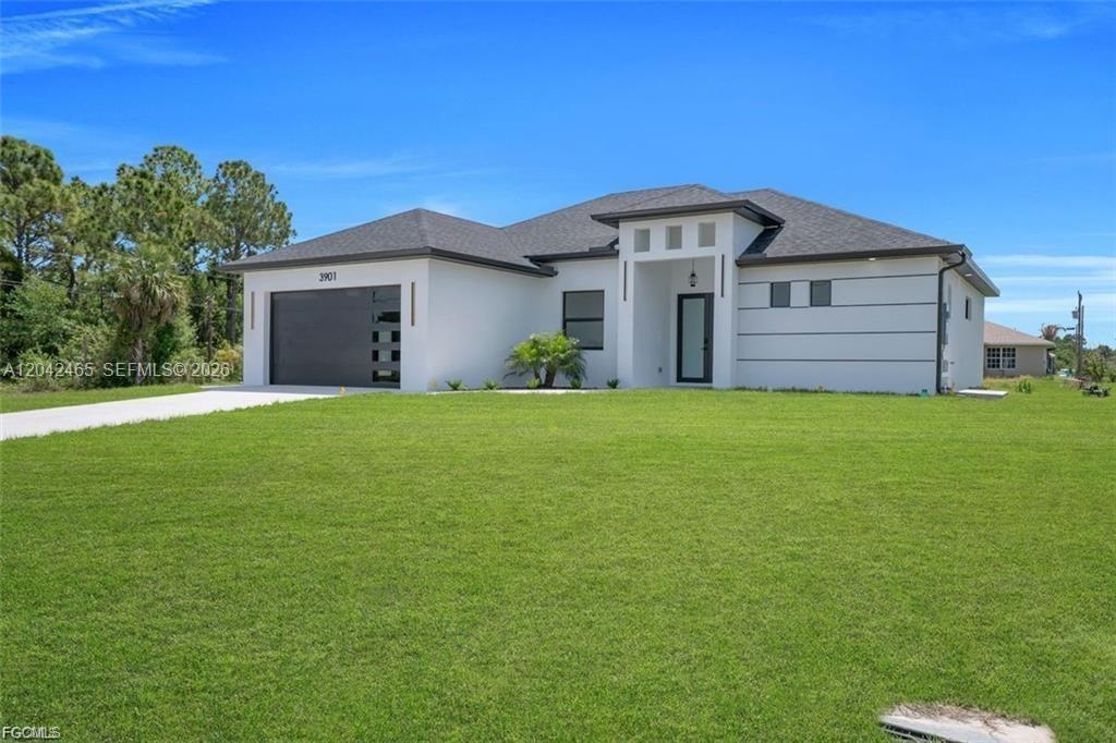 A modern, single-story white house with a dark garage door and a flat-roofed entryway — 3901 3rd ST SW, Lehigh Acres FL 33976, LEHIGH ACRES, FL