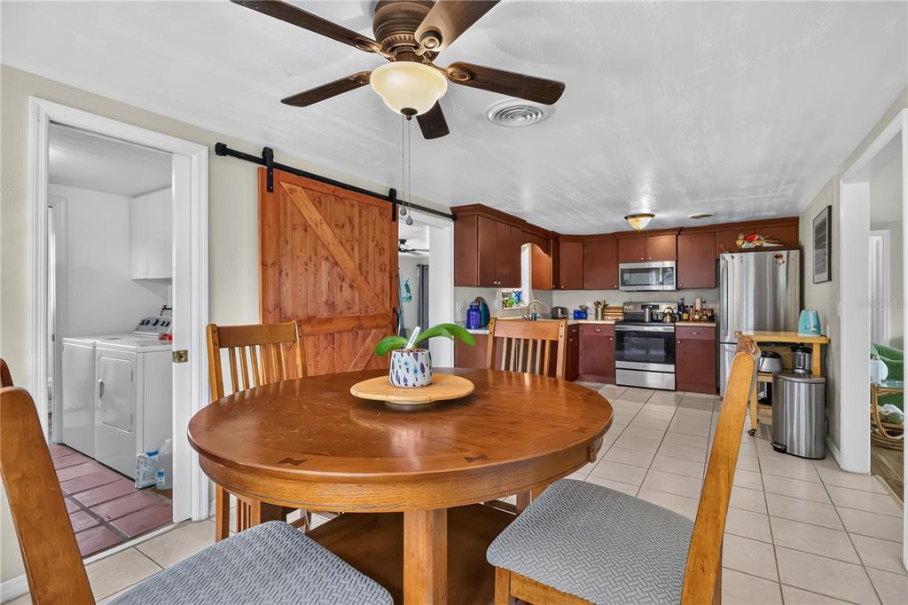 A screened-in porch features wicker furniture, a blue door, and a decorative wall sign — 535 CARUSO PLACE, SARASOTA, FL