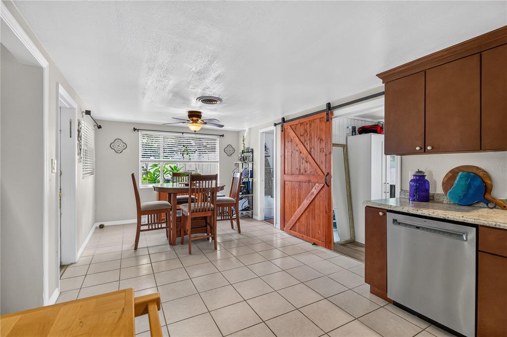 A screened-in porch features wicker furniture, a rug, and views of a neighborhood street — 535 CARUSO PLACE, SARASOTA, FL