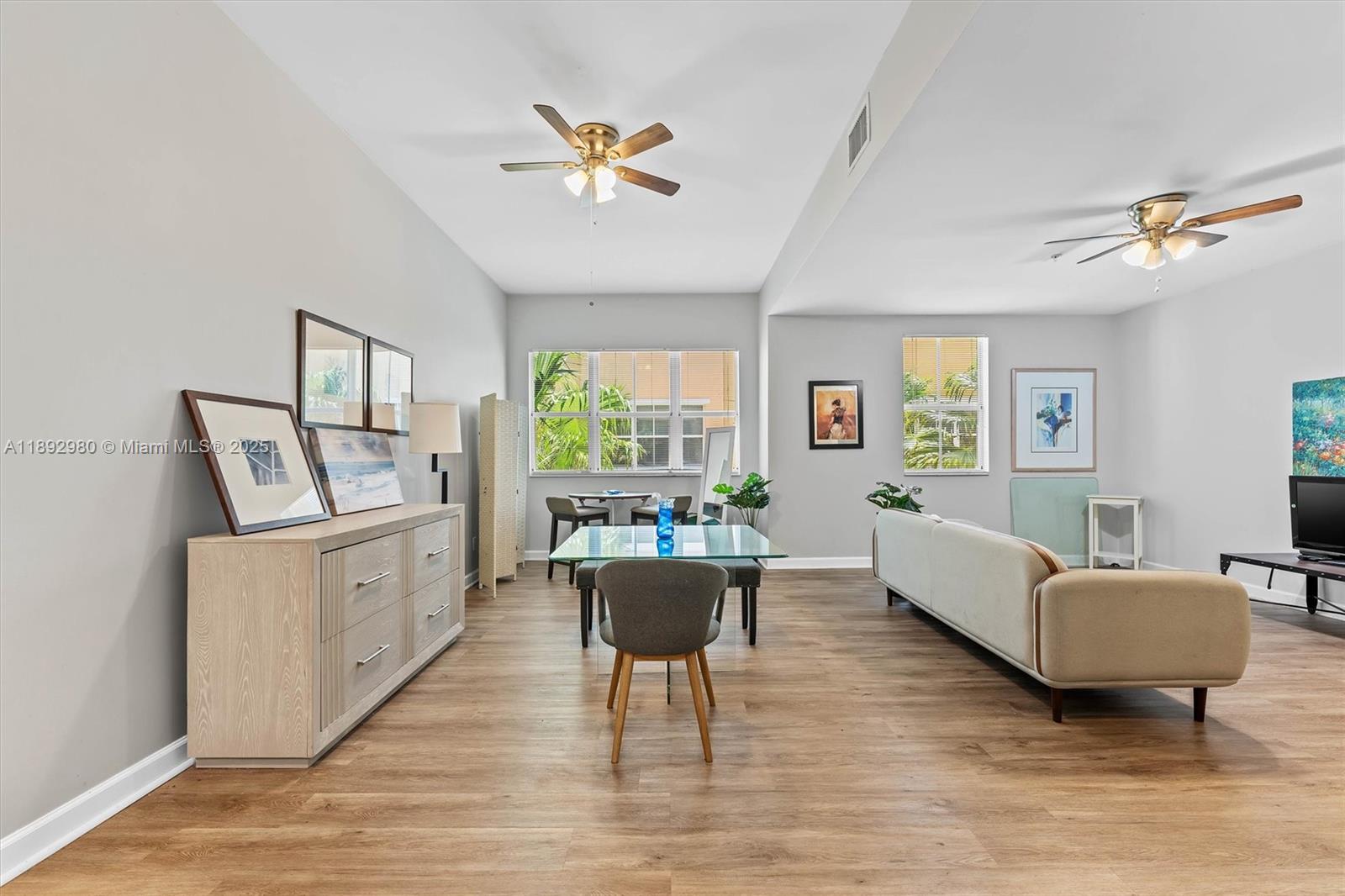 A living and dining area features light wood flooring, ceiling fans, and neutral walls — 2344 Vintage Dr, Lighthouse Point FL 33064, LIGHTHOUSE POINT, FL