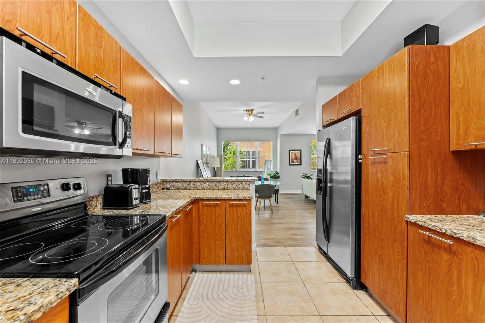 A kitchen features wood cabinets, granite countertops, stainless steel appliances, and tile flooring — 2344 Vintage Dr, Lighthouse Point FL 33064, LIGHTHOUSE POINT, FL