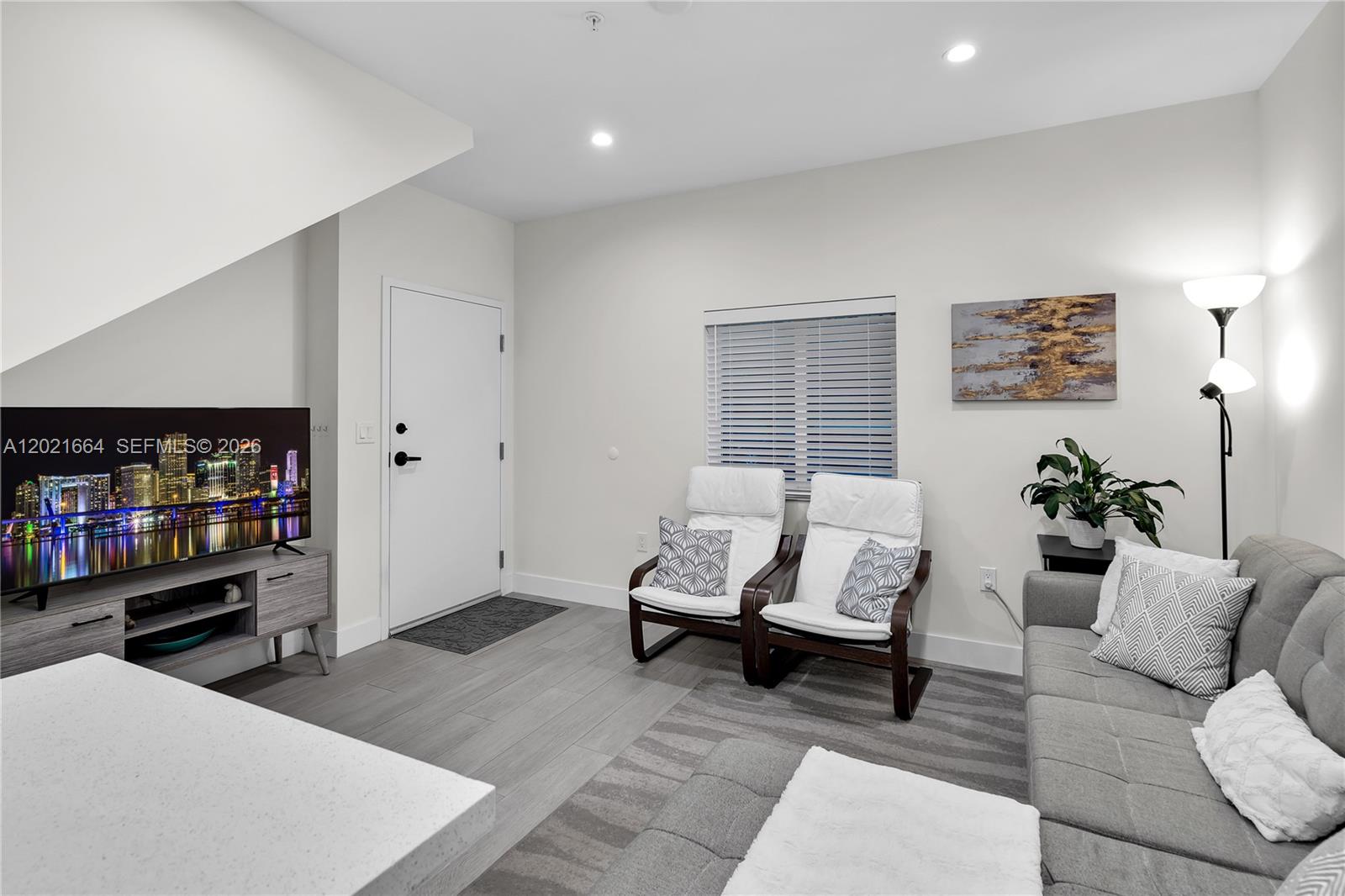 A living room features a gray sofa, two white armchairs, a television, and tile flooring — 1786 SW 9th St # 1, Miami FL 33135, MIAMI, FL