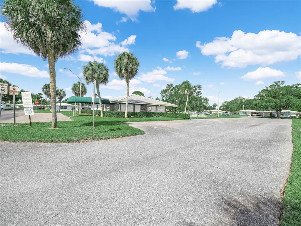 A paved parking area leads to a single-story building with palm trees and green landscaping — 601 IMPERIAL BOULEVARD, LAKELAND, FL