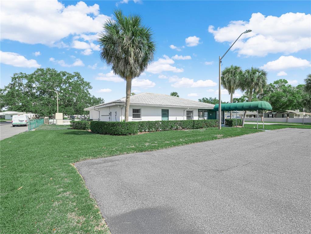 A white single-story building features a green awning and a tall palm tree outside — 601 IMPERIAL BOULEVARD, LAKELAND, FL