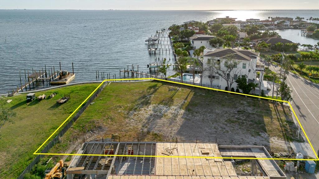 An aerial view shows a vacant waterfront lot with a partially constructed concrete building foundation — 5102 W LONGFELLOW AVENUE, TAMPA, FL