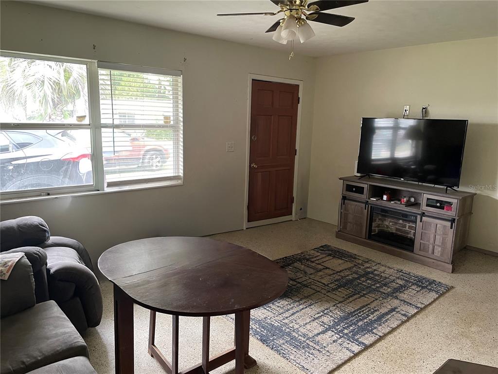 A living room features a round table, a television on a media console, and tile flooring — 2209 NE 36TH STREET, OCALA, FL