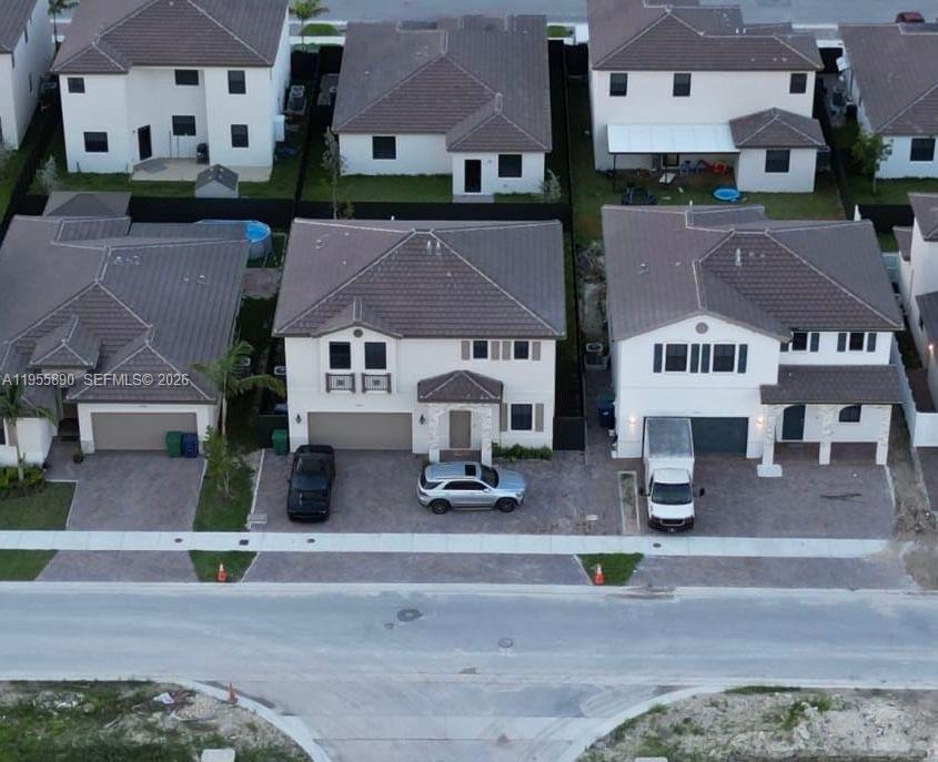 An aerial view shows three suburban houses with driveways and cars parked in front — 12961 SW 230th St, Miami FL 33170, MIAMI, FL
