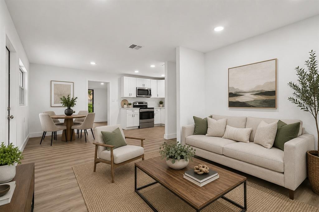 A living room with a sofa and coffee table opens to a dining area and kitchen — 1207 32ND STREET NW, WINTER HAVEN, FL