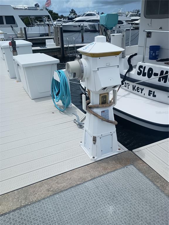A white utility pedestal stands on a dock next to a boat at a marina — 2600 HARBOURSIDE DRIVE UNIT P-05, LONGBOAT KEY, FL