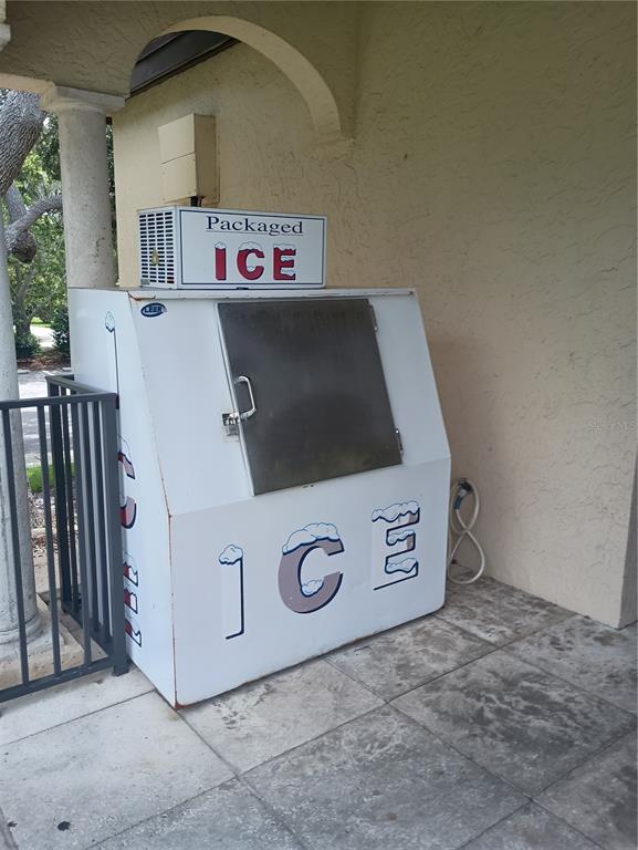 A white, outdoor packaged ice vending machine sits on a tiled patio near a pillar — 2600 HARBOURSIDE DRIVE UNIT P-05, LONGBOAT KEY, FL