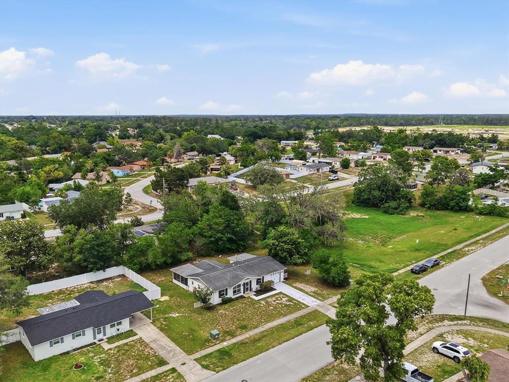 An aerial view shows a residential neighborhood with single-story houses, green lawns, and trees — 9269 MARLER ROAD, SPRING HILL, FL